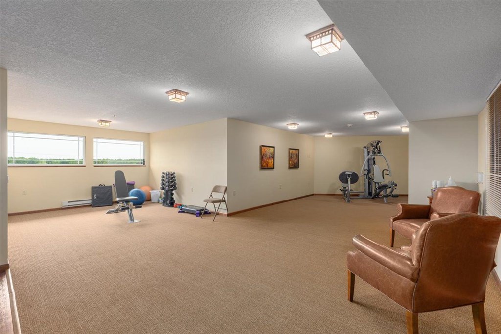 A room with a brown chair and exercise equipment.