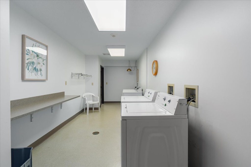 A white room with a sink and a chair.