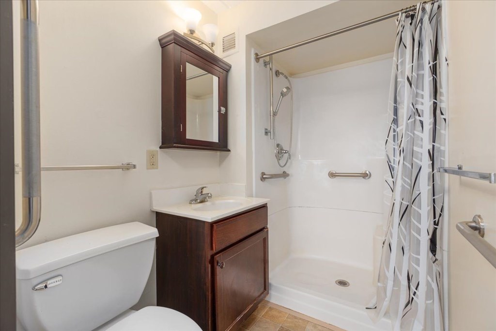 A white bathtub sits next to a white sink in a bathroom.