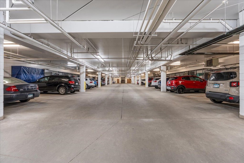 A spacious parking garage with multiple cars parked.
