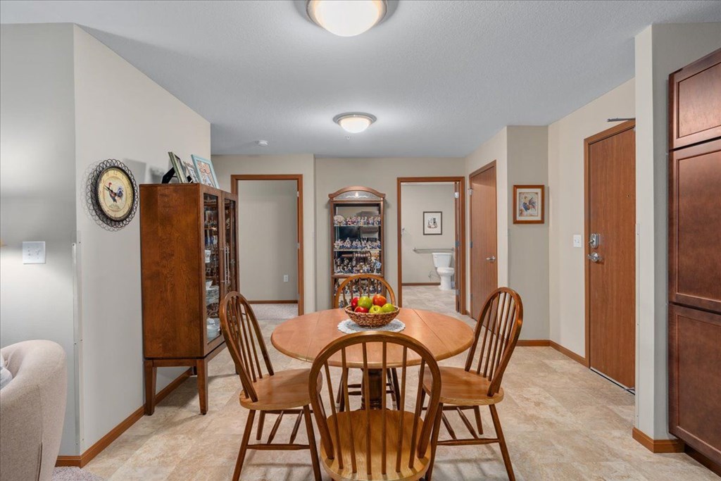 A dining room with a wooden table and chairs.