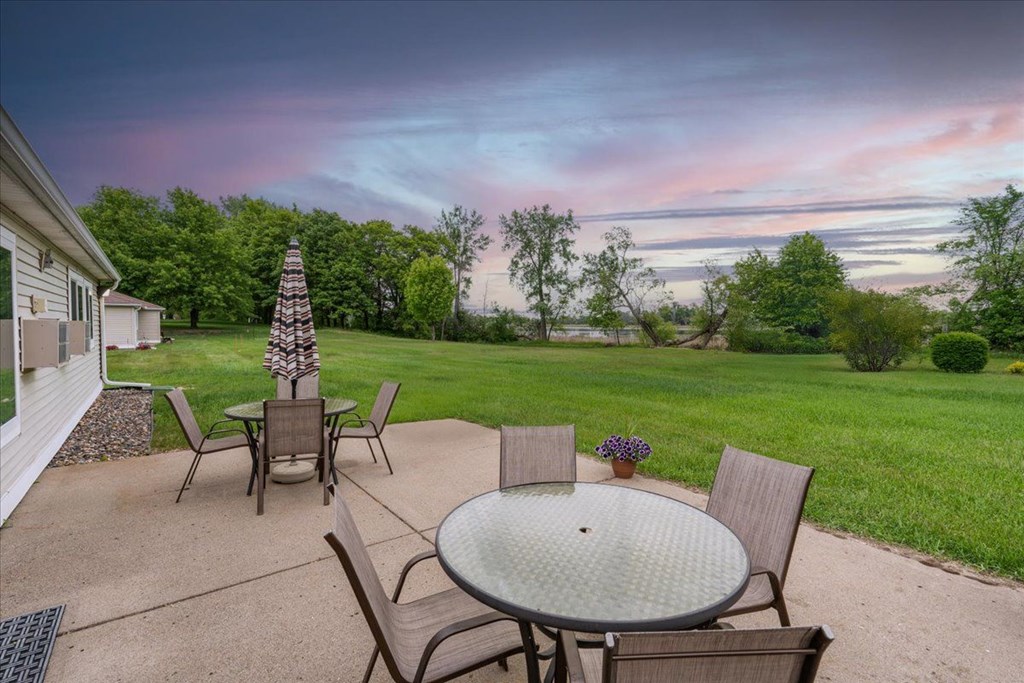 A patio with a table and chairs is set up for an evening outside.