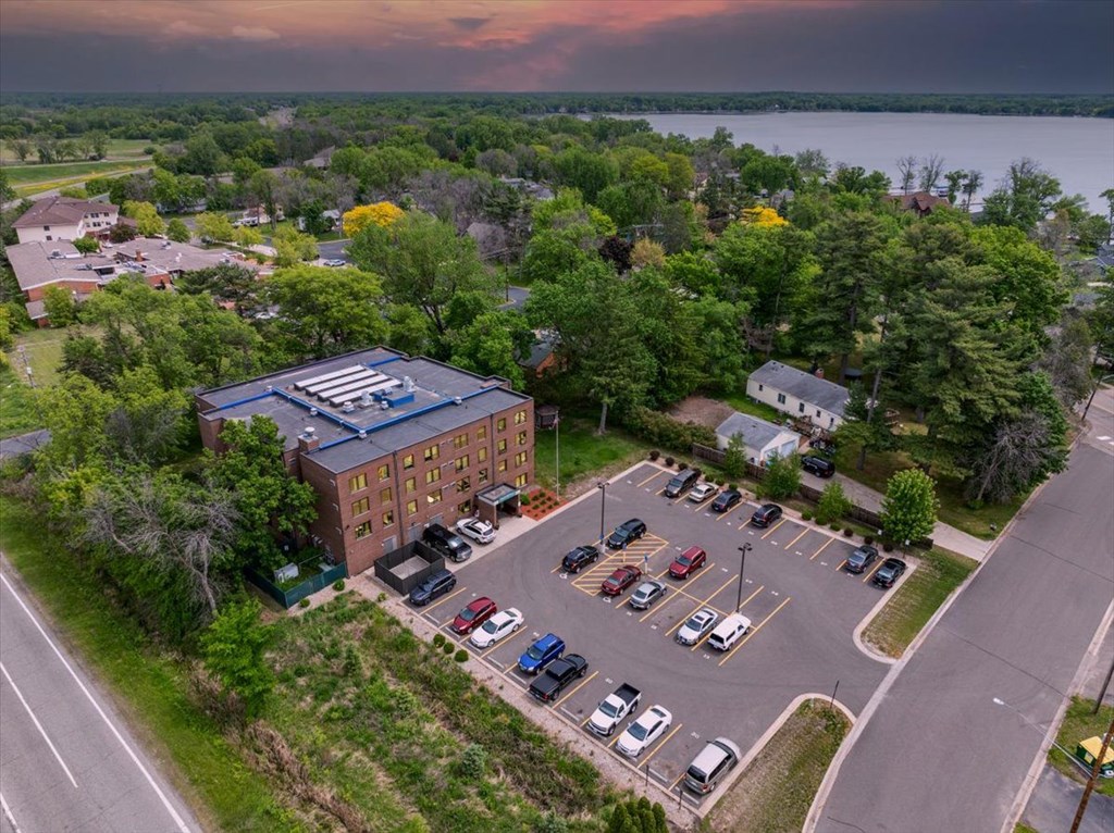 A parking lot with cars and a building in the background.