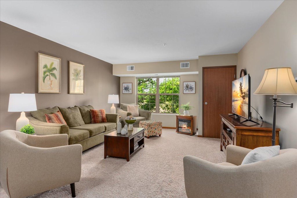 A living room with a couch, chairs, and a television.
