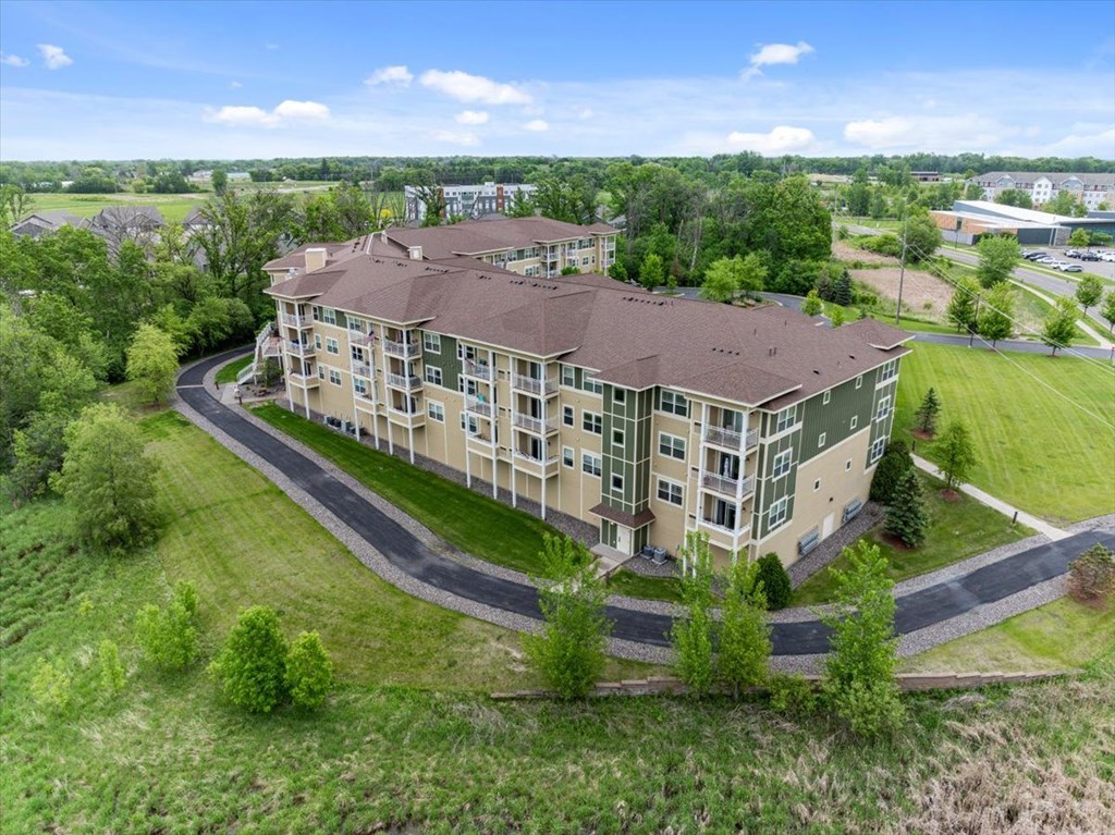 A large apartment complex with a curved driveway in front.