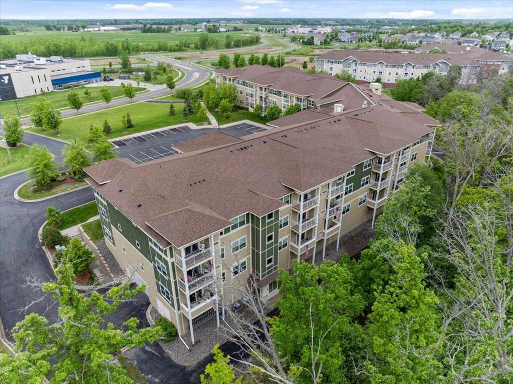 A large apartment complex with a parking lot in front.