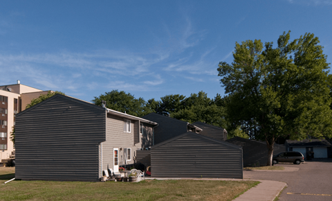a row of houses in a neighborhood with a blue sky