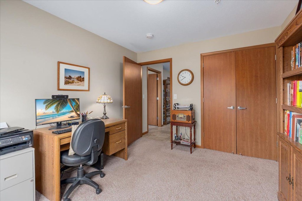 A room with a desk, chair, and bookshelf.