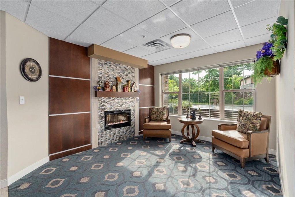 A living room with a fireplace and a blue carpet.