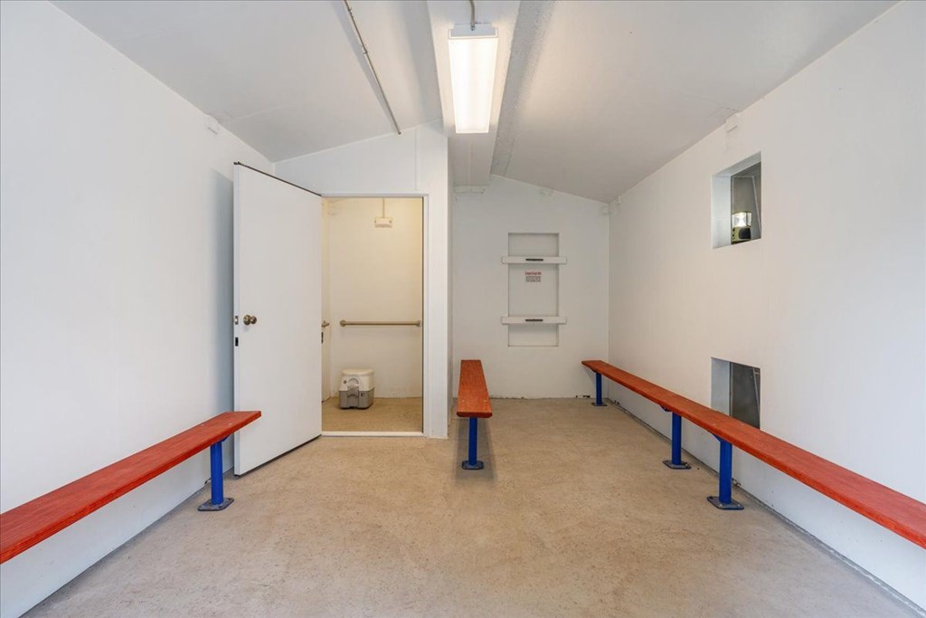 A room with a bench and a door.