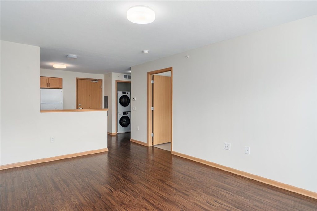A room with a white wall and a brown door.