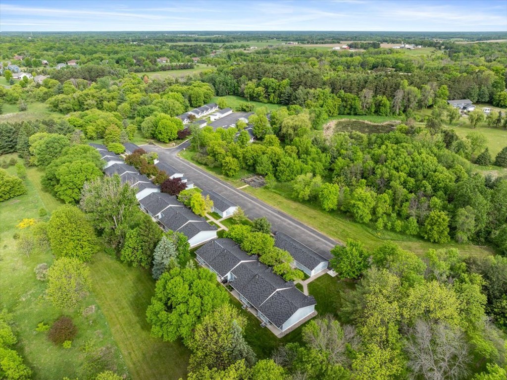 A long row of houses with trees in the front.