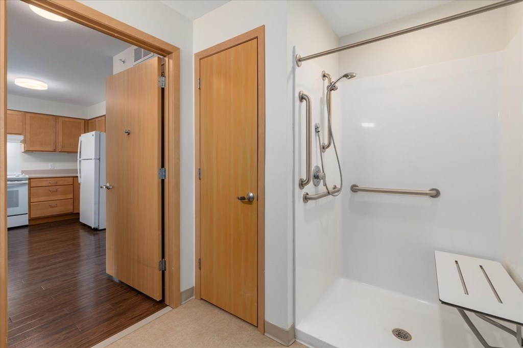 A bathroom with a walk in shower and a sink.