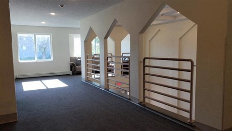 an empty room with a staircase and a book shelf