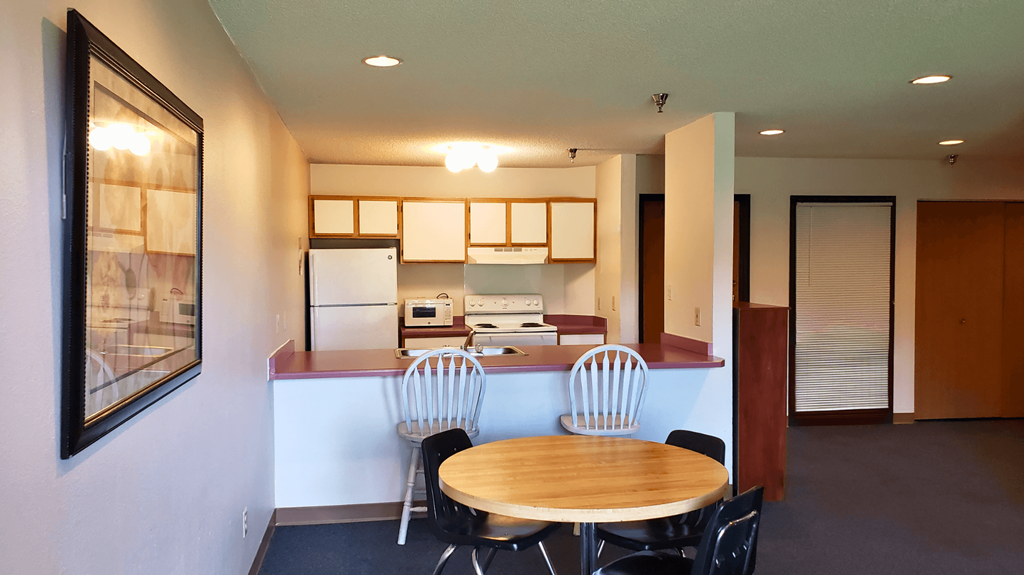 a kitchen and dining room with a table and chairs