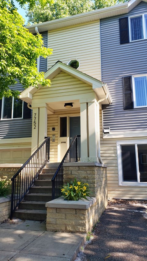 the front of a house with stairs and a porch