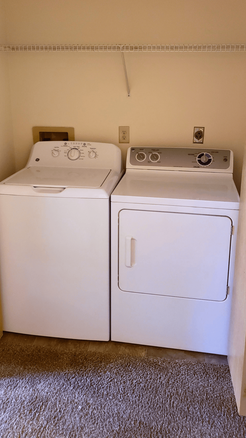 a washer and dryer in a room with a carpeted floor
