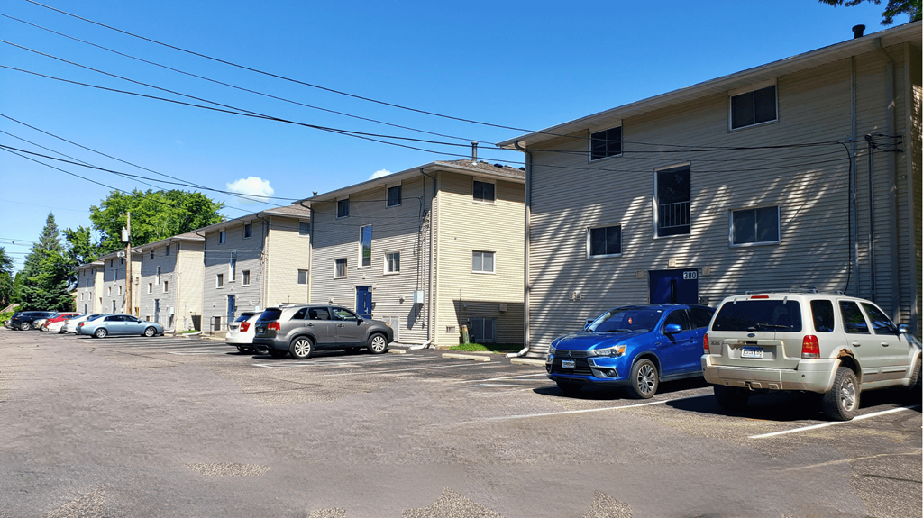 a parking lot filled with cars in front of buildings