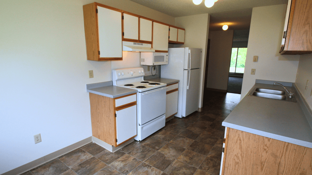 a kitchen with white appliances and wooden cabinets