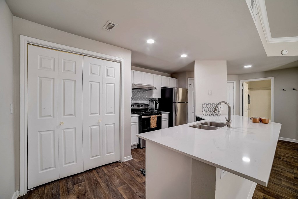 a kitchen with a white counter top and a sink