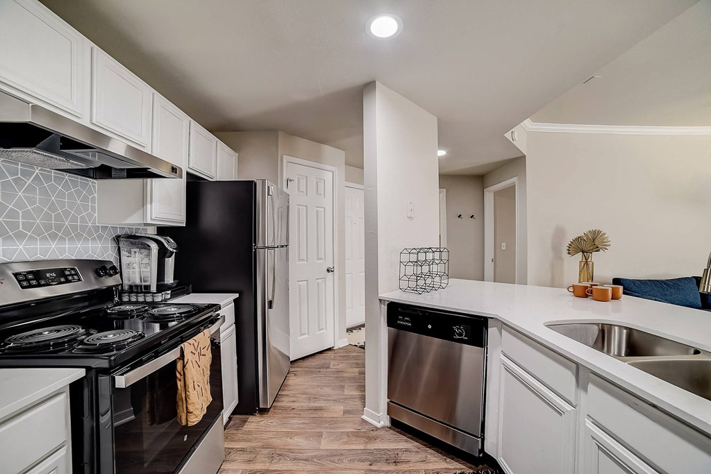 a kitchen with stainless steel appliances and white cabinets