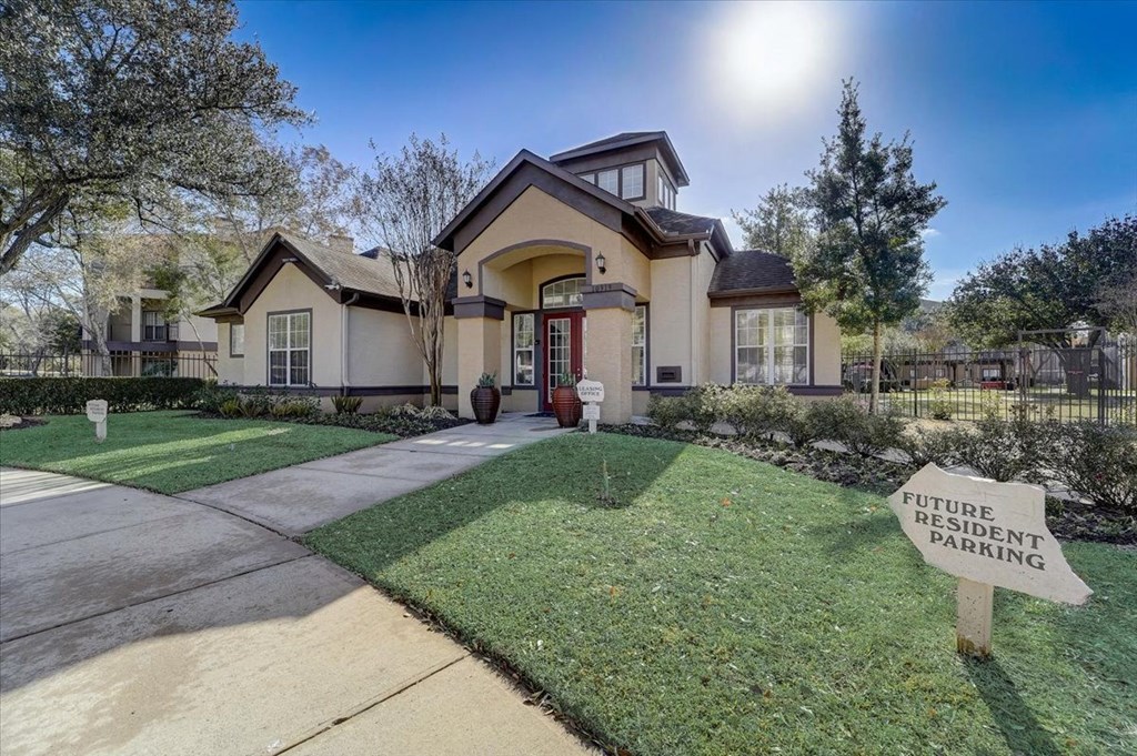 the front of a house with a yard and a sign in the grass