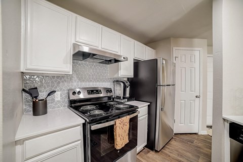 a kitchen with black appliances and white cabinets