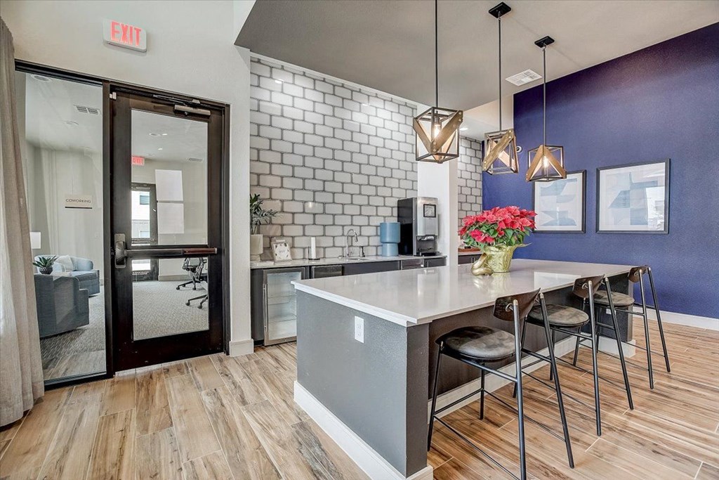 a kitchen with a counter and stools in front of a blue wall