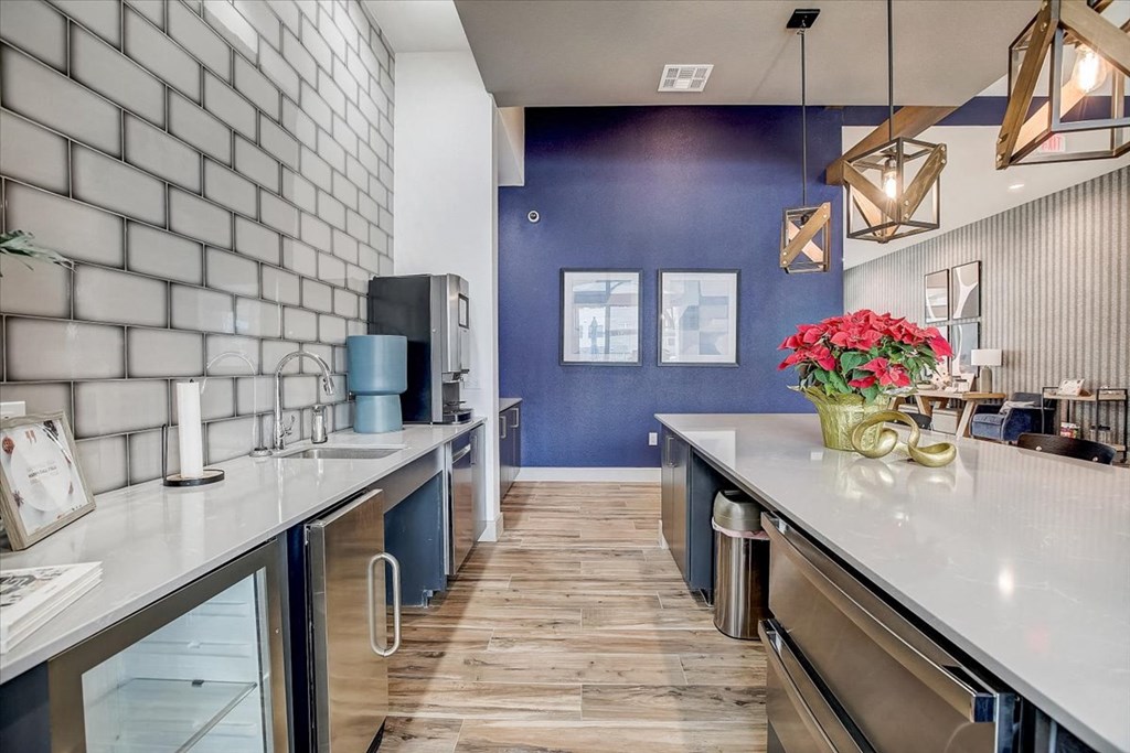 a kitchen with a long counter and a blue wall and a counter with flowers