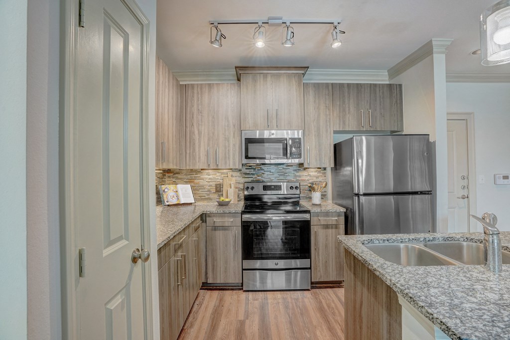 a kitchen with granite counter tops and stainless steel appliances