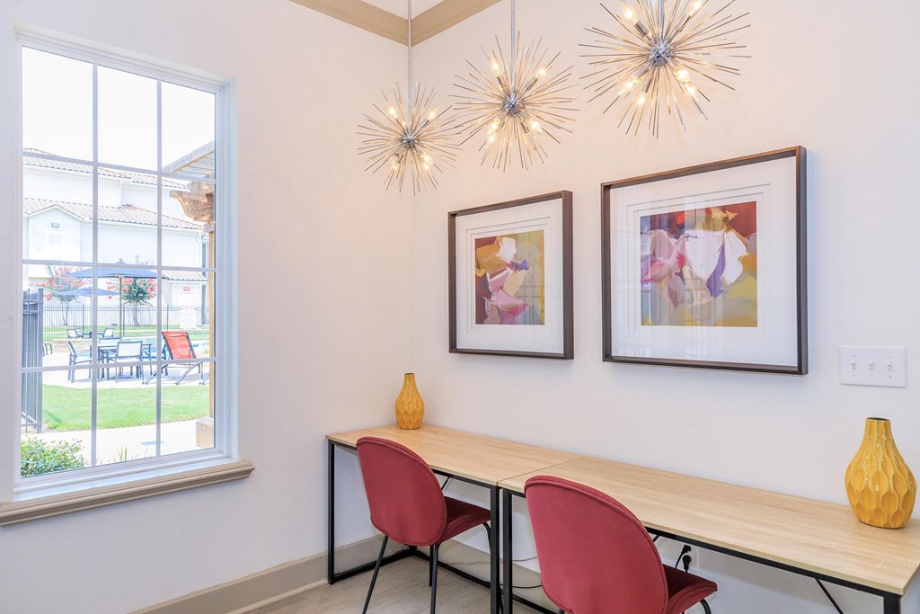 A table with two chairs and two hanging lights.
