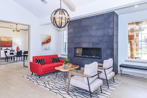 A modern living room with a red couch and a fireplace.