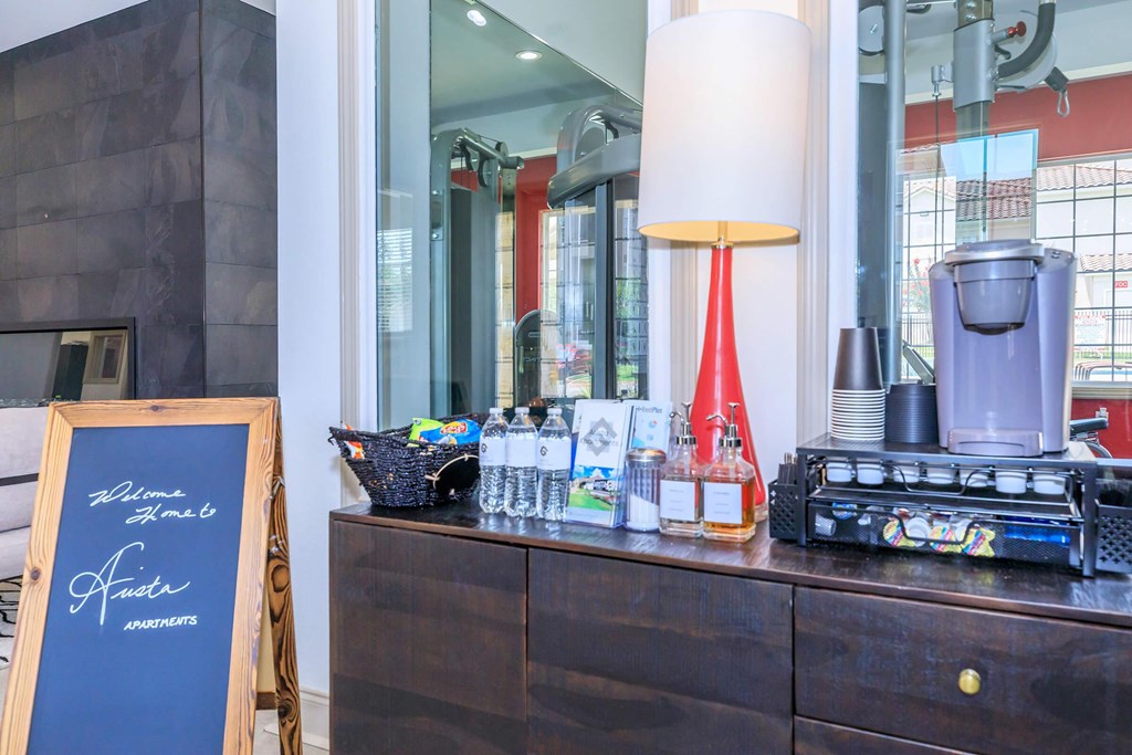 A sign that says Welcome and a bottle of oil on a table.