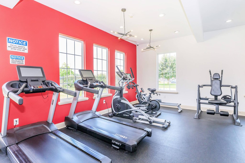 A gym with treadmills, exercise bikes, and weights.