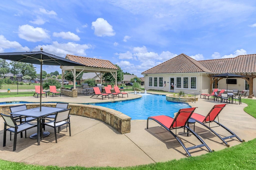 A poolside area with a table and chairs.