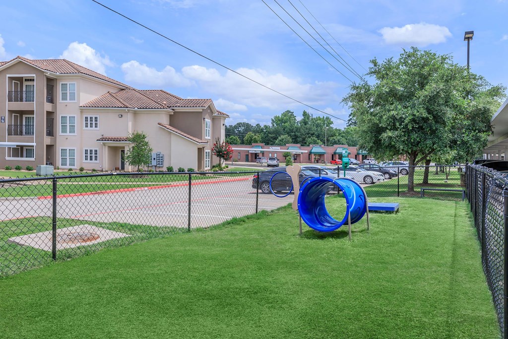 A playground with a blue slide and a baseball diamond.