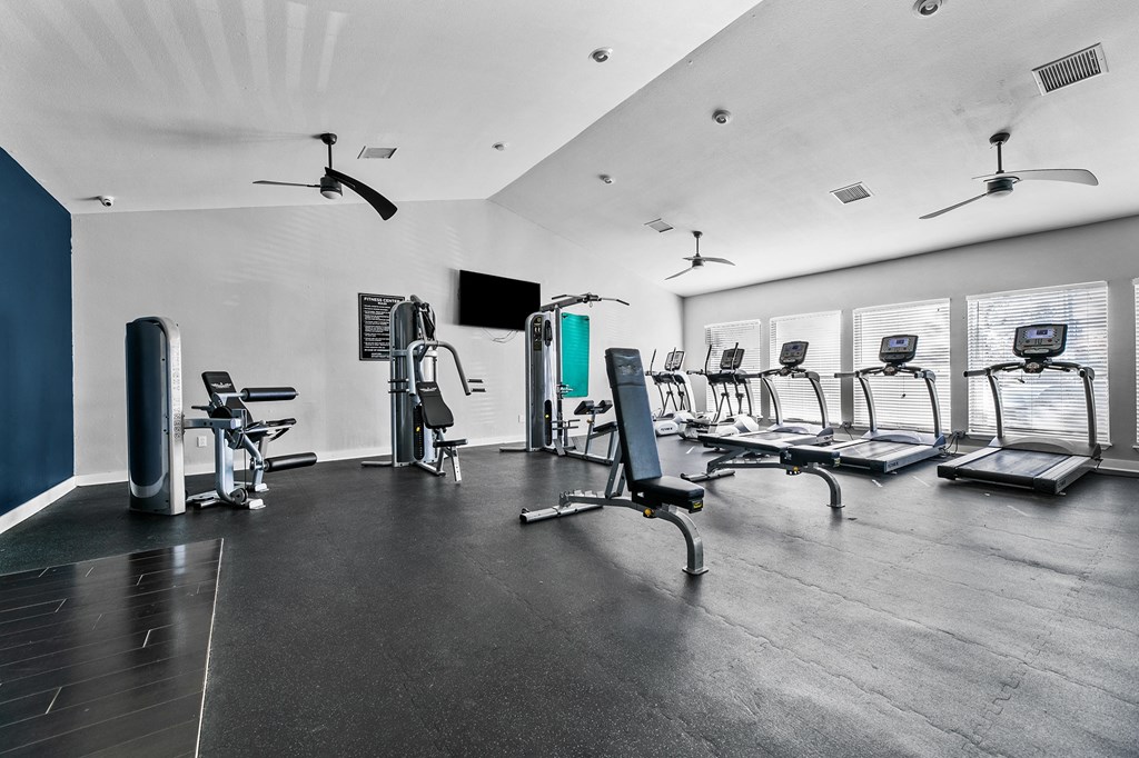 a fitness room with treadmills and other exercise equipment