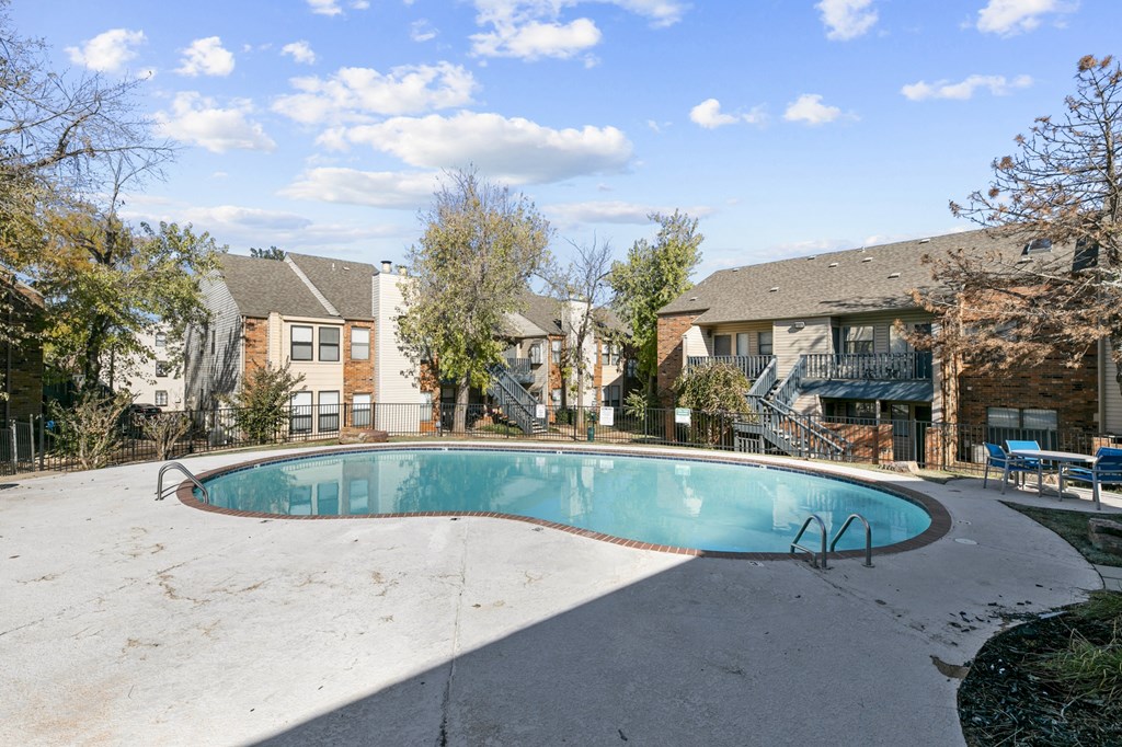 a swimming pool with apartment buildings in the background