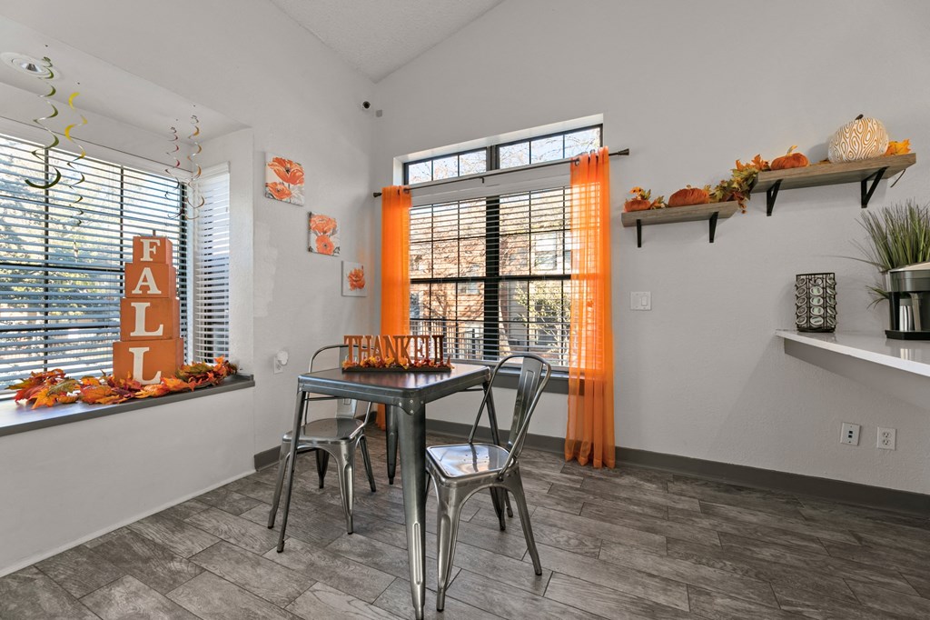a dining area with a table and chairs and a window