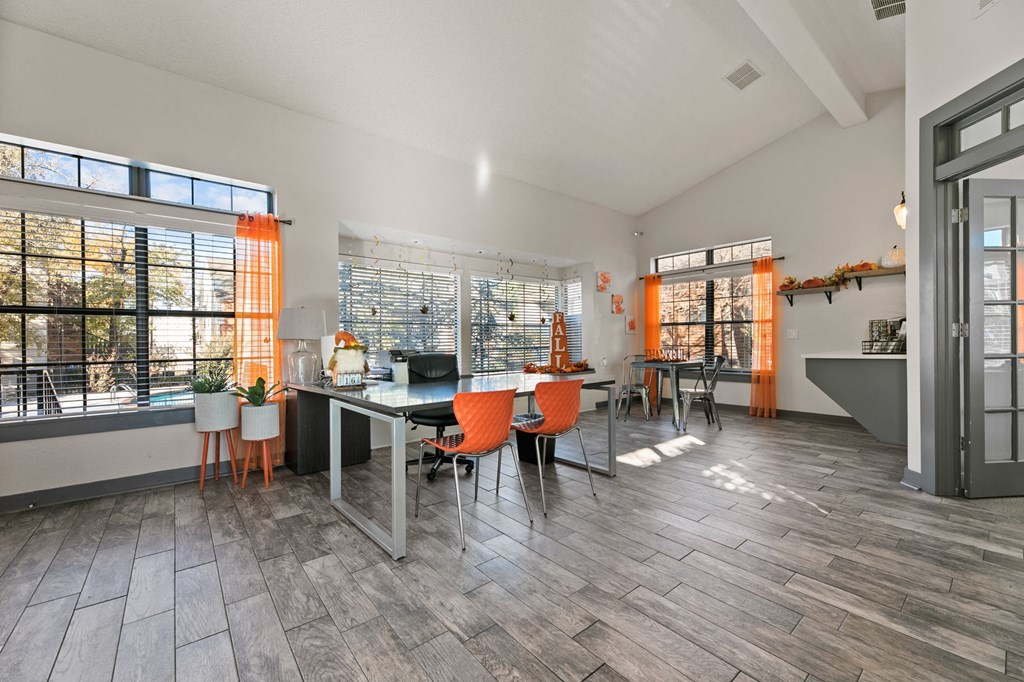 a dining room with a table and chairs and a kitchen with large windows