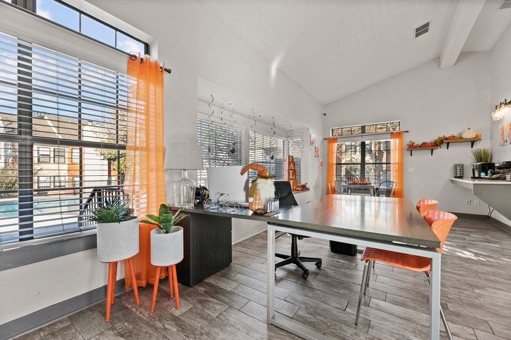 a home office with a desk and chairs and a large window