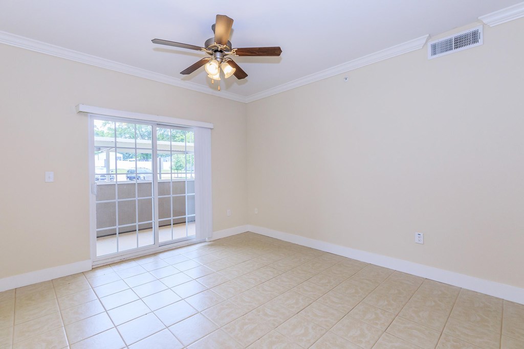 A room with a ceiling fan and tiled floor.