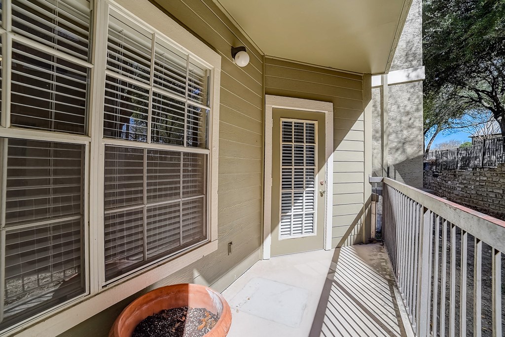 a porch with a door and a balcony with windows