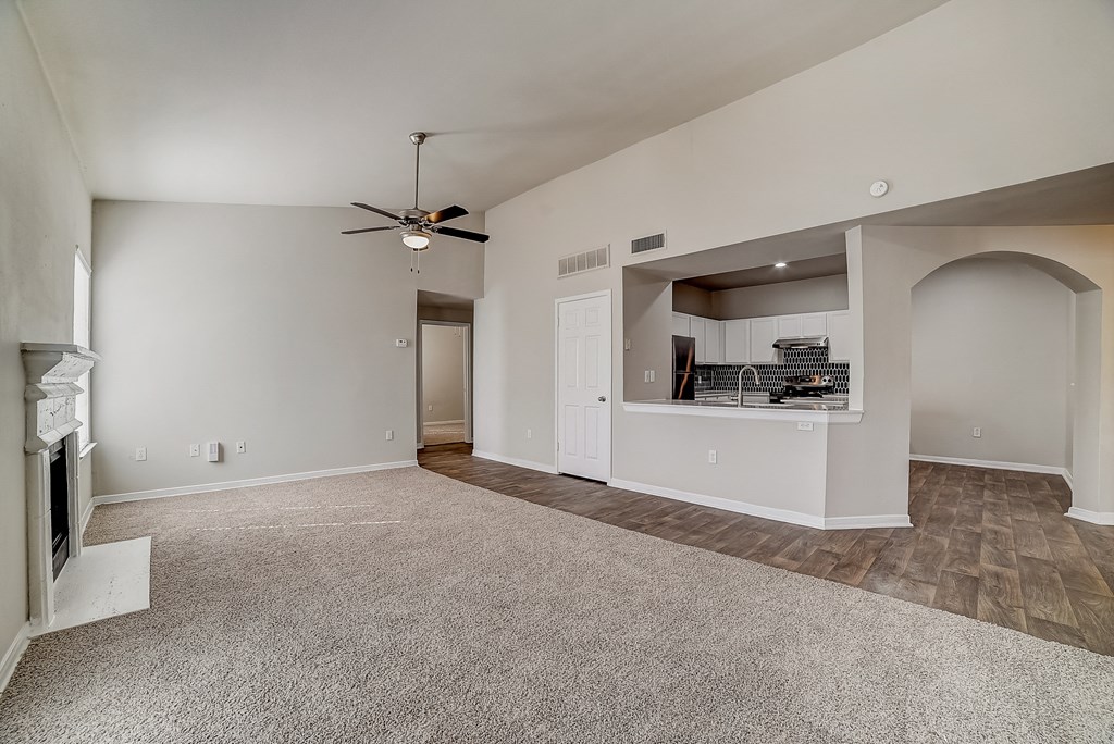 the living room and kitchen in a new home with a ceiling fan