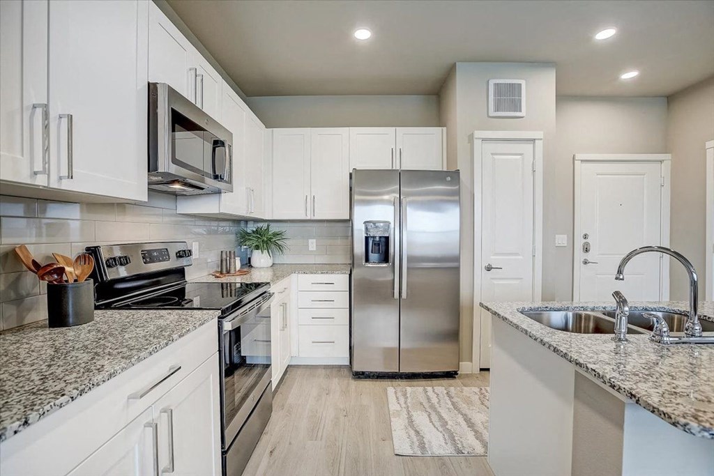 a kitchen with a stainless steel refrigerator  and a sink