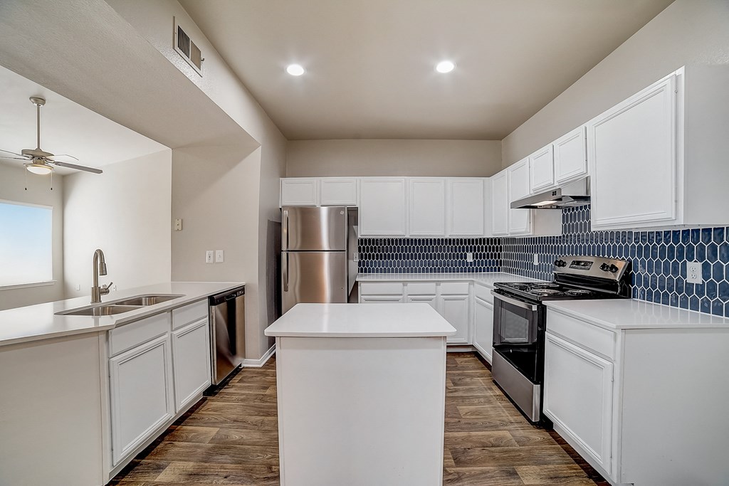 an empty kitchen with white cabinets and stainless steel appliances