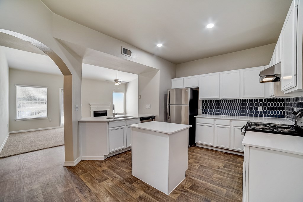 an open kitchen with white cabinets and stainless steel appliances