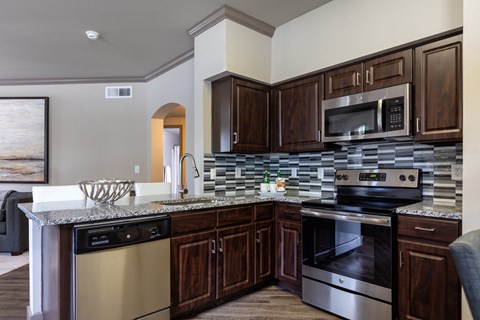 a kitchen with wooden cabinets and stainless steel appliances