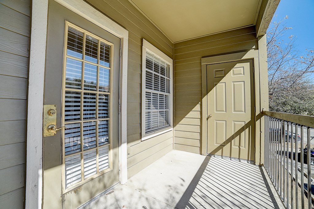 the front porch of a home with a white door