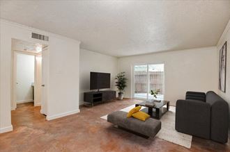 a living room with white walls and a large window